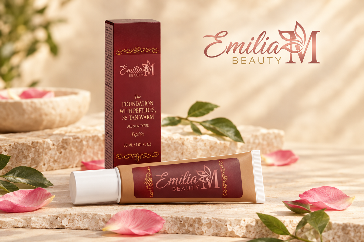 Emilia M Beauty Foundation with Peptides in 35 Tan Warm displayed with its burgundy box, greenery and pink petals in a warm beige setting